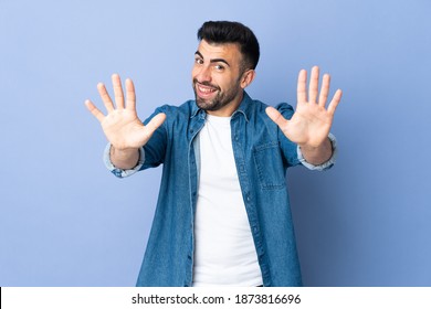 Caucasian man over isolated blue background counting ten with fingers