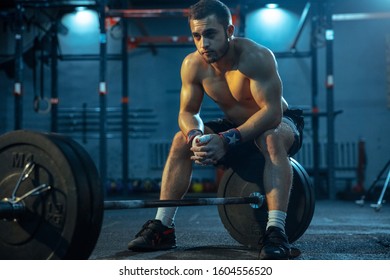 Caucasian man practicing in weightlifting in gym. Caucasian male sportive model posing before training, looks confident and strong. Body building, healthy lifestyle, movement, activity, action concept