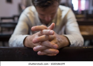 caucasian man praying in church. He has problems and ask God for help. Concept of religion faith