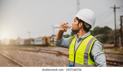 Caucasian Man Railway Engineer Drink Water From Bottle In The Site Work Of Train Garage.