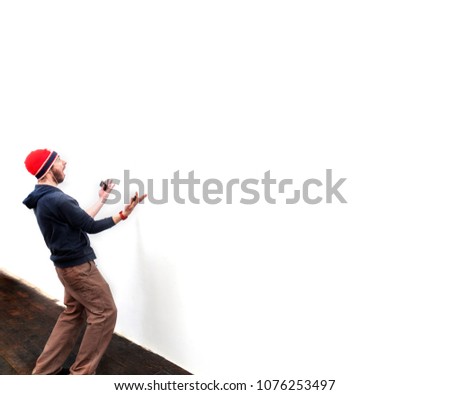 A caucasian man reacts to something on a wall.