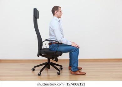 Caucasian Man Sitting On The Edge Of Office Chair In Correct Posture