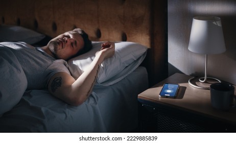 Caucasian Man Sleeps through Smartphone Alarm Clock Showing Eight in the Morning. Tired Person Oversleeping. Person and Mobile Phone Close-up. Bedside Nightstand Bedroom Apartment - Shutterstock ID 2229885839