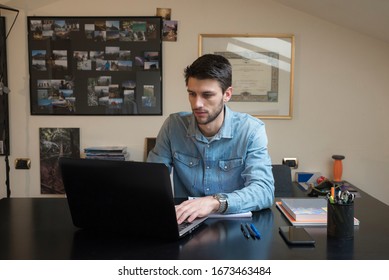 Caucasian man smart working at home during the coronavirus quarantine. Typing on the laptop with home background. Business