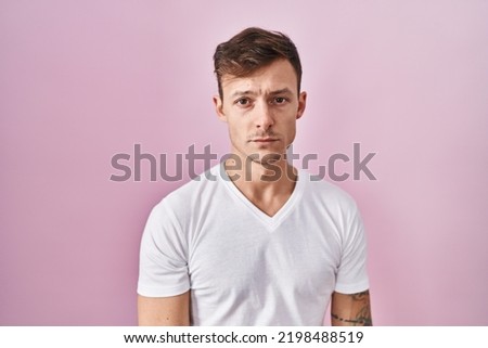 Caucasian man standing over pink background depressed and worry for distress, crying angry and afraid. sad expression. 