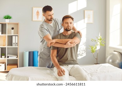 Caucasian man therapist performs a arm massage for a patient during rehabilitation and therapy session in office. Physiotherapy and sports medicine in the physical recovery process. - Powered by Shutterstock