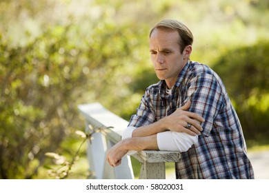 Caucasian man thinking on wooden bridge