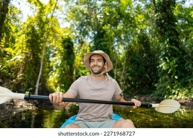 Caucasian man tourist enjoy outdoor lifestyle kayaking at mangrove forest on summer vacation. Handsome guy traveler canoeing or row the boat on lake. Environmental ecotourism and solo travel concept. - Powered by Shutterstock