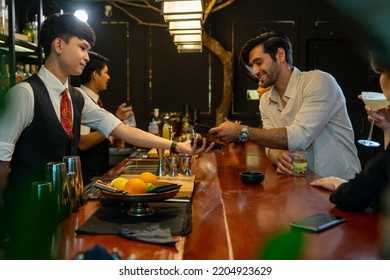 Caucasian Man Using Mobile Banking Application On Smartphone Scan QR Code Making Online Payment While Hangout Party At Restaurant Bar. Electronic Banking And Contactless Payment Technology Concept.