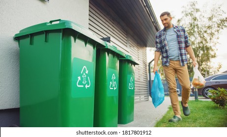 Caucasian Man Is Walking Outside His House In Order To Take Out Two Plastic Bags Of Trash. One Garbage Bag Is Sorted With Biological Food Waste, Other Is With Recyclable Bottles. Saving Environment.