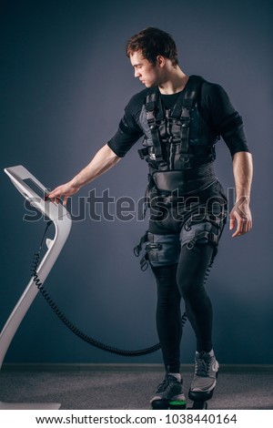 Caucasian man wearing biometric fitness vest training on stepper with electric muscle stimulation