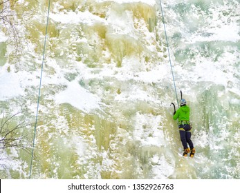 Caucasian Man Wearing Blue Jacket Climbing Ice Wall