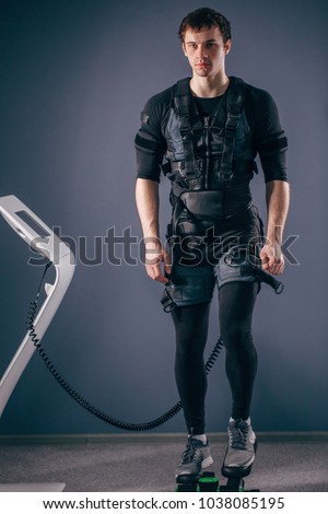 Caucasian man wearing ems suit training on stepper