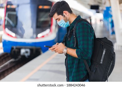 Caucasian man wearing surgical masks waiting to board the public train.