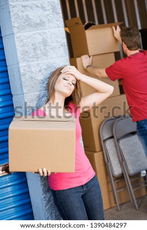 Caucasian man and woman with various props at a typical commercial storage unit.
