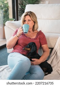 Caucasian Mature Woman With Cup Of Coffee Smiling With Her Dachshund Dog