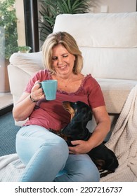 Caucasian Mature Woman With Cup Of Coffee Smiling With Her Dachshund Dog