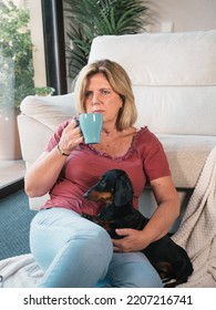 Caucasian Mature Woman With Cup Of Coffee Smiling With Her Dachshund Dog