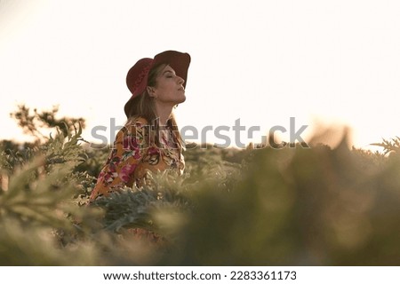 caucasian mature woman in a flowery dress and pretty earrings calm and relaxed with her eyes closed and her head raised