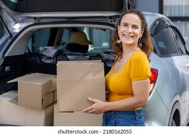 Caucasian Mature Woman Is Holding Cardboard Box To Packing Inside The Car For House Moving And Relocation