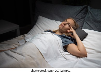 Caucasian Mature Woman Lost In Her Thoughts While Lying On Comfy Bed At Night. Female Person With Blond Hair Unable To Sleep Because Of Life Problems.