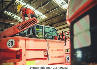 Caucasian Mechanic Checking The Digger Machine In His Heavy Duty Industrial Equipment Workshop. Regular Machinery Check And Maintenance Procedure.