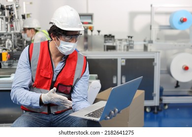 Caucasian Mechanic Technician Maintenance, Repairing Industrial Machinery Equipment In Factory. Professional Worker In Protective Clothing With Goggles And Mask Using Computer At Manufacturing Factory