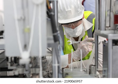 Caucasian Mechanic Technician Maintenance, Repairing Industrial Machinery Equipment In Factory. Professional Worker In Protective Clothing With Goggles And Mask Using Wrench At Manufacturing Factory