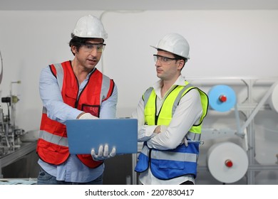 Caucasian Mechanic Technician Maintenance, Repairing Industrial Machinery Equipment In Factory. Professional Worker In Protective Clothing With Computer And Mask Using Wrench At Manufacturing Factory