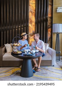 Caucasian Men And Asian Women Having A Luxury High Tea With Snacks And Tea In A Luxury Hotel