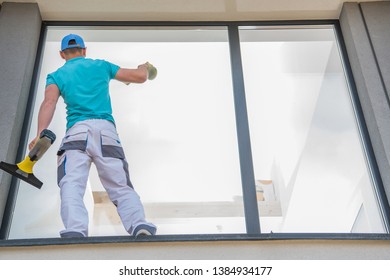 Caucasian Men Cleaning Large Residential Window Outside Of The House. Cleaning Service Business.