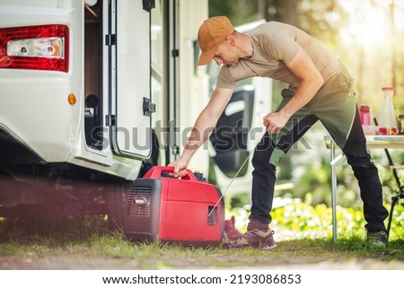 Caucasian Men Firing Portable Inverter Generator Connected to His Motor Home RV. Summer Camping Power Supply.