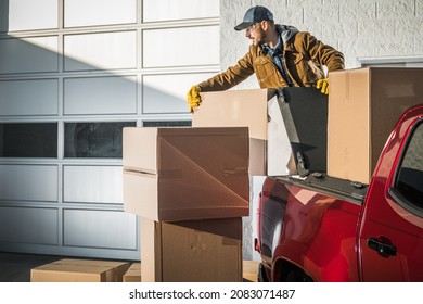 Caucasian Men In His 40s And Large Moving Boxes Delivery Using Pickup Truck. Commercial Gate Unloading.