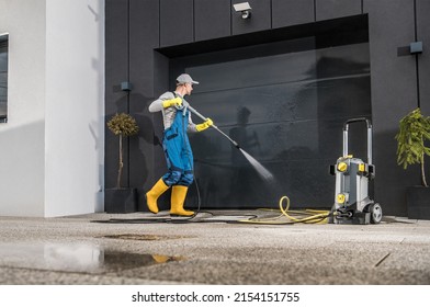 Caucasian Men Pressure Washing His Garage Gate Using Powerful Washer. Keeping the Gate and Driveway Clean.  - Shutterstock ID 2154151755