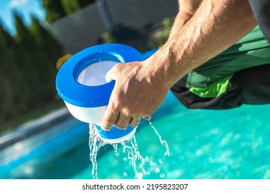 Caucasian Men Removing Chemical Dispenser From His Outdoor Swimming Pool To Load New Chlorine Tables. Water Treatment Theme.