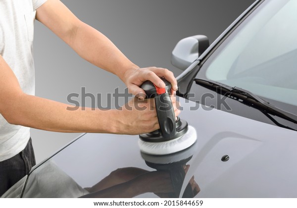 Caucasian men varnishing car with car polisher\
on studio background
