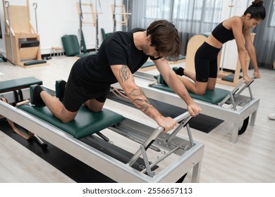 Caucasian men and woman training pilates with pilates equipment in fitness studio	 - Powered by Shutterstock