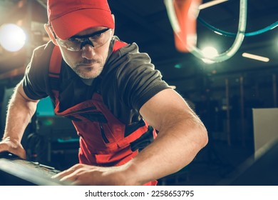 Caucasian Metalworking Industry Worker in His 40s in Eyes Safety Glasses Operating a Machine. - Powered by Shutterstock