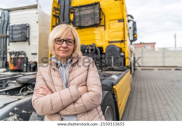 Caucasian mid age woman driving\
truck. trucker female worker, transport industry occupation\
