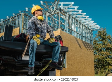 Caucasian Middle Aged Contractor Proudly Sitting On The Front Panel Of His Pickup Truck Cargo Bed. Tools Are Packed In The Trunk After Finished Day At Work. 