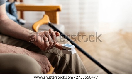 Caucasian middle aged man using pulse oximeter at home