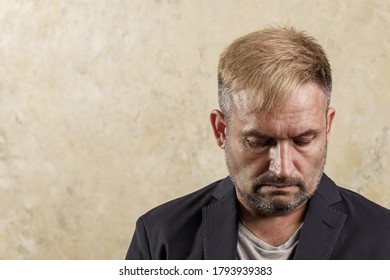 Caucasian Middle-aged Pensive Man. Lowered Gaze. Not Looking At The Camera. Copy Space