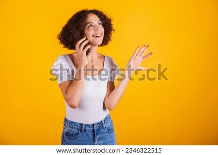 Caucasian model, in white shirt and blue jeans, holding cell phone, voice call.