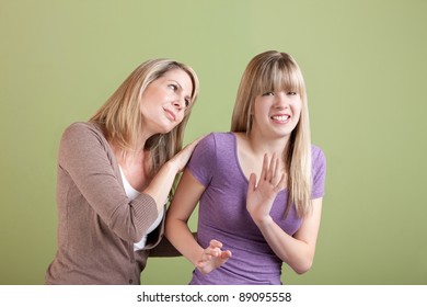 Caucasian Mom With Annoyed Daughter Over Green Background