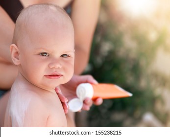 Caucasian Mom Does Sunblock On Her Baby In The Air