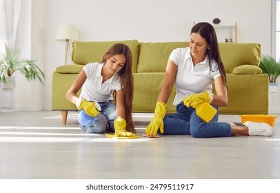 Caucasian mother and daughter wearing in gloves bond while cleaning the living room at home, smiling as they wipe the floor together, sharing household chores and enjoying their togetherness. - Powered by Shutterstock