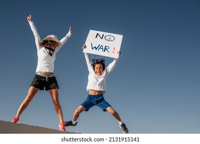 A Caucasian Mother In A White Hat, Jumps Next To Her Asian Son Holding A Sign That Reads 