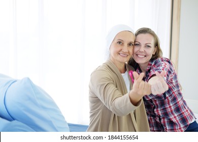 Caucasian Mother And Young Daughter Making Mini Heart Hand For Love With Caring And Encouragement For Elderly Mother Is Suffering From Cancer Or Leukemia Patient After Chemotherapy.