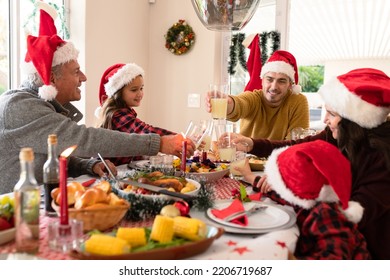 Caucasian Multi Generation Family Wearing Santa Hats Having Christmas Meal. Family Christmas Time And Festivity Together At Home.