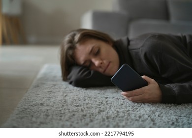 Caucasian Nervous Woman Lying Down On The Floor With Mobile Phone 